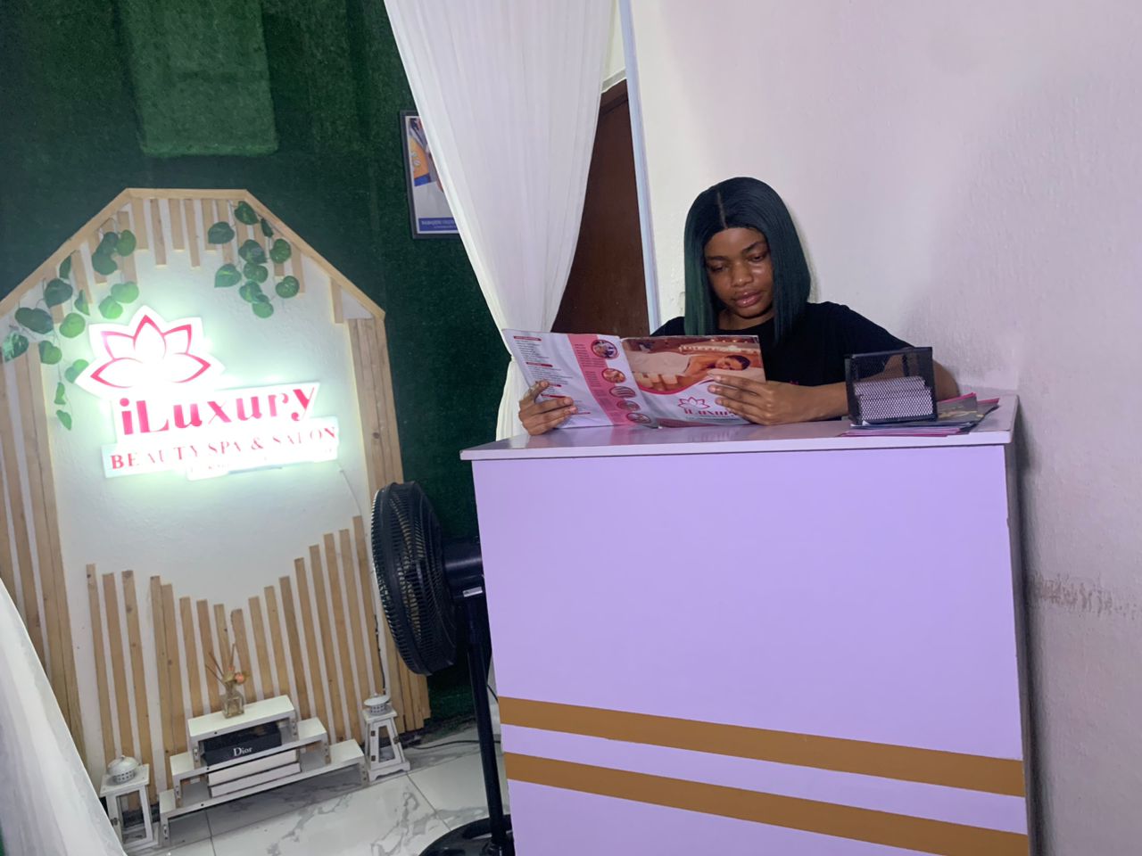 The iLuxury reception desk and illuminated salon sign